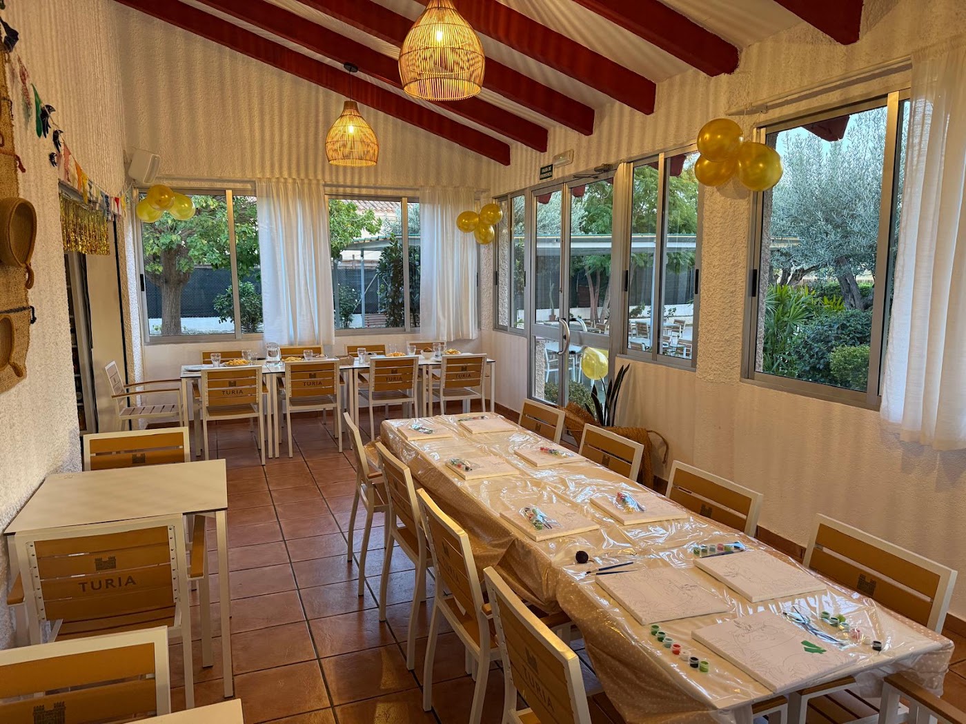 Salón de El Laguito con mesa larga y ventanales al jardín